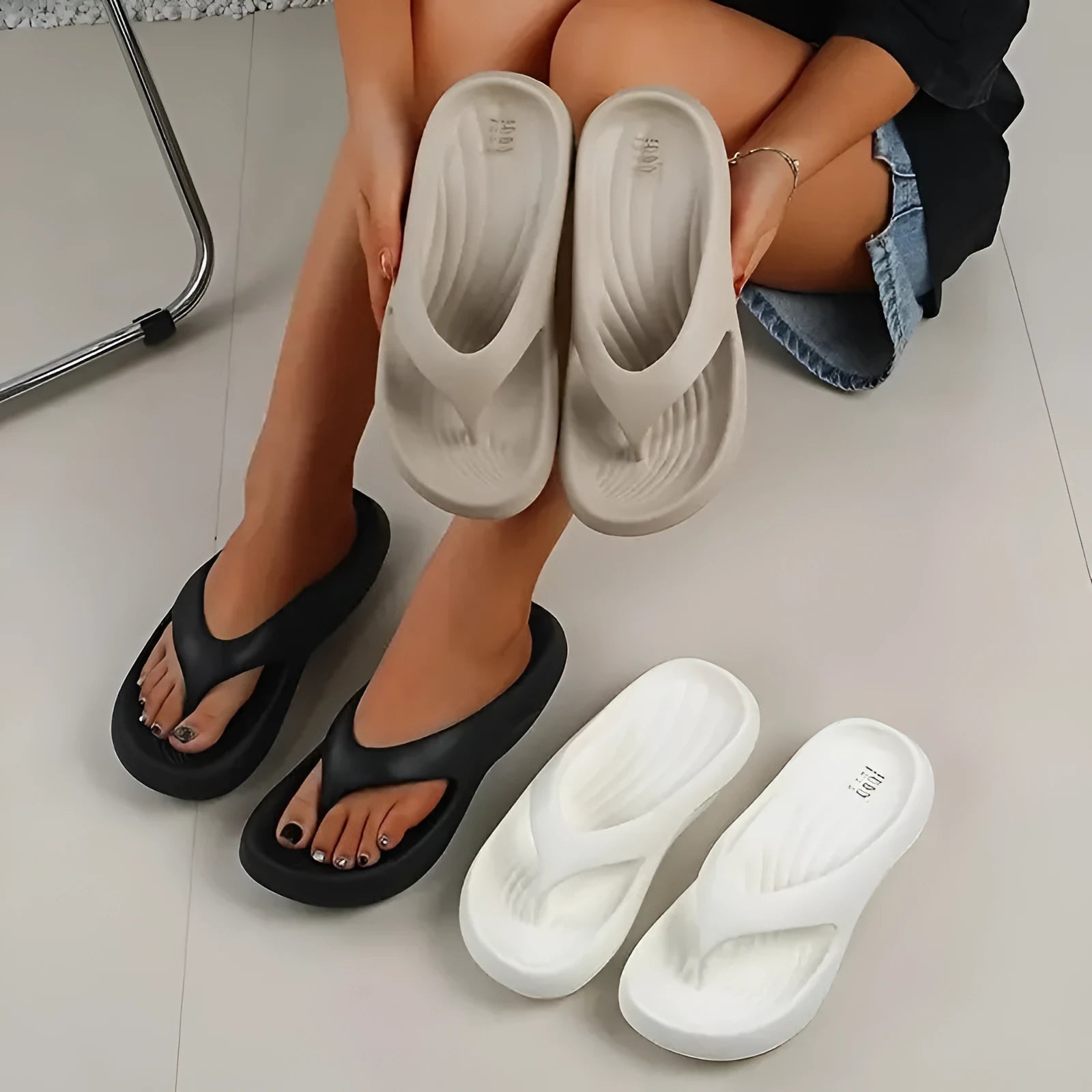 Women's black flip-flops with a thick textured sole and non-slip pattern.