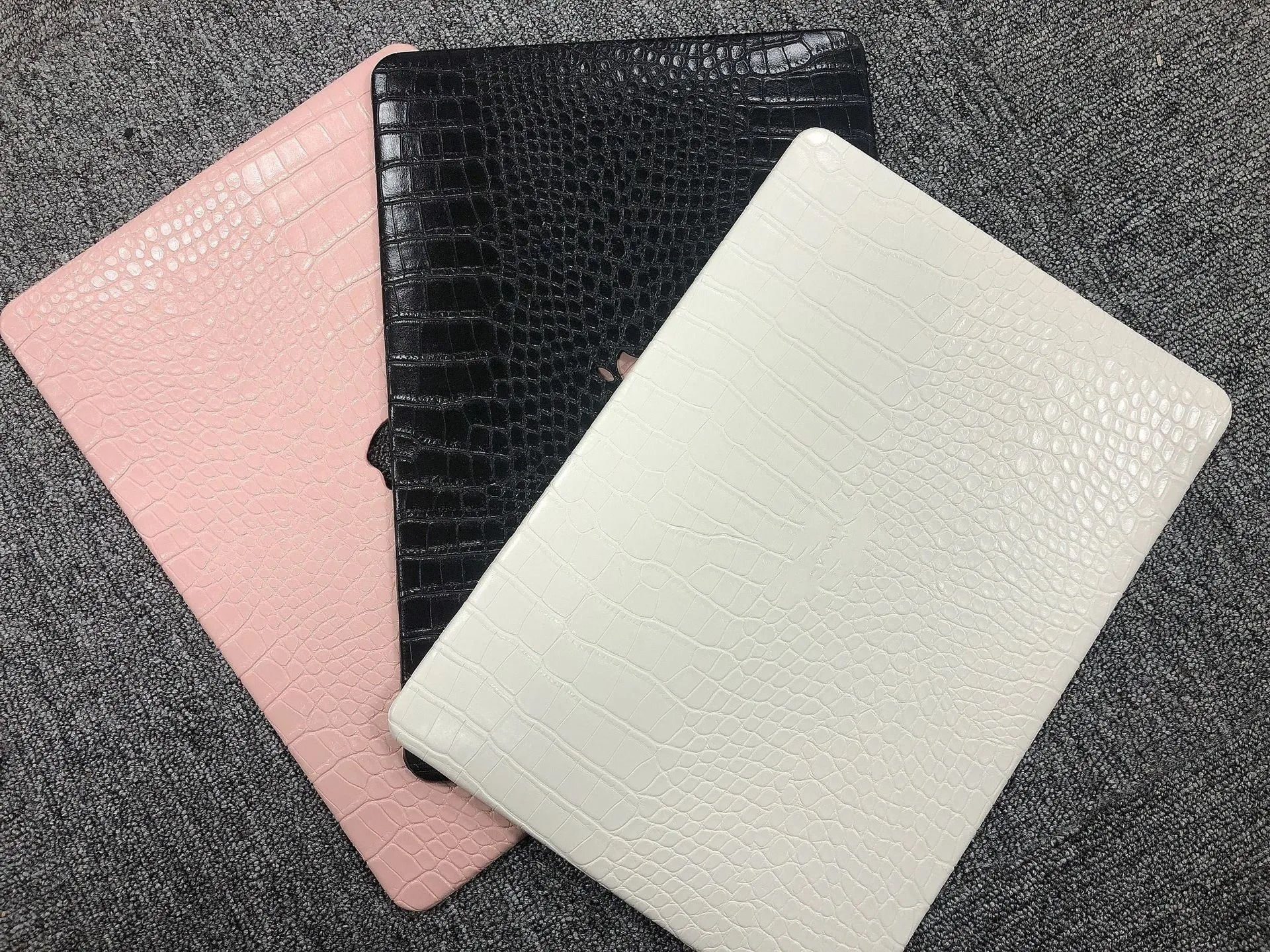 MacBook protective case with crocodile pattern texture and hollowed-out Apple logo design in black colour