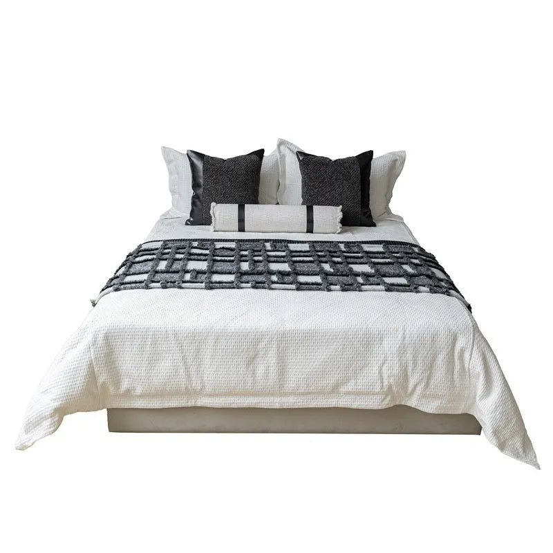 Modern minimalist grey and white plaid bed runner blanket set with pillow on a double bed.