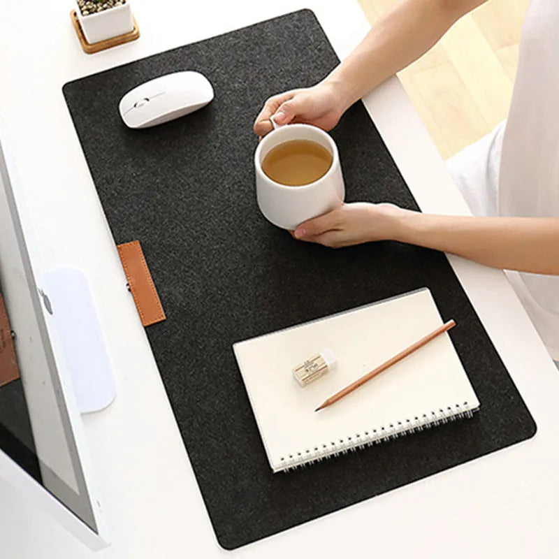 Large black felt desk mat with sewn edges, measuring 325x635mm, on an office desk with a keyboard and mouse.