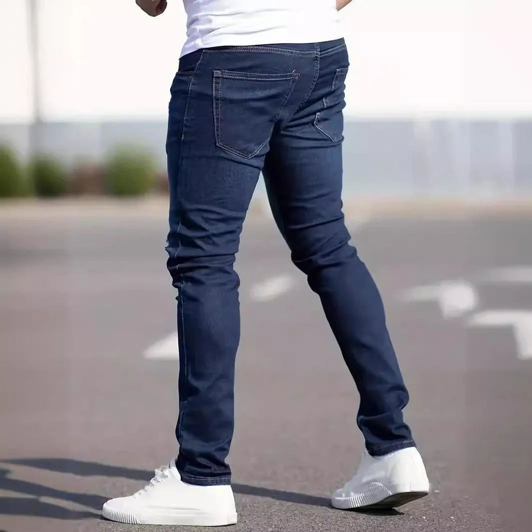 Man wearing dark blue slim-fit skinny jeans with a mid waist and zip fly.