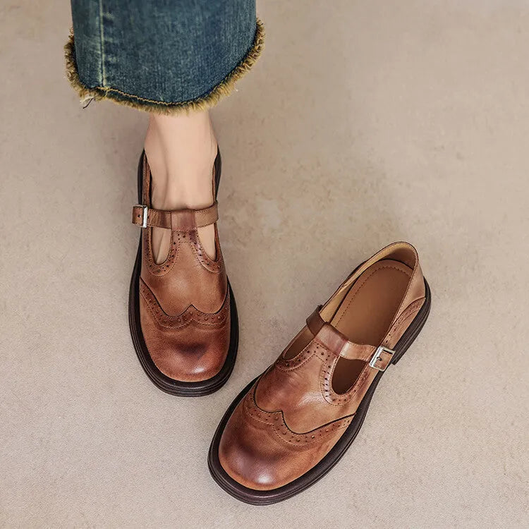 Women's black British style leather flat shoe with round toe and slip-on design on a neutral background.