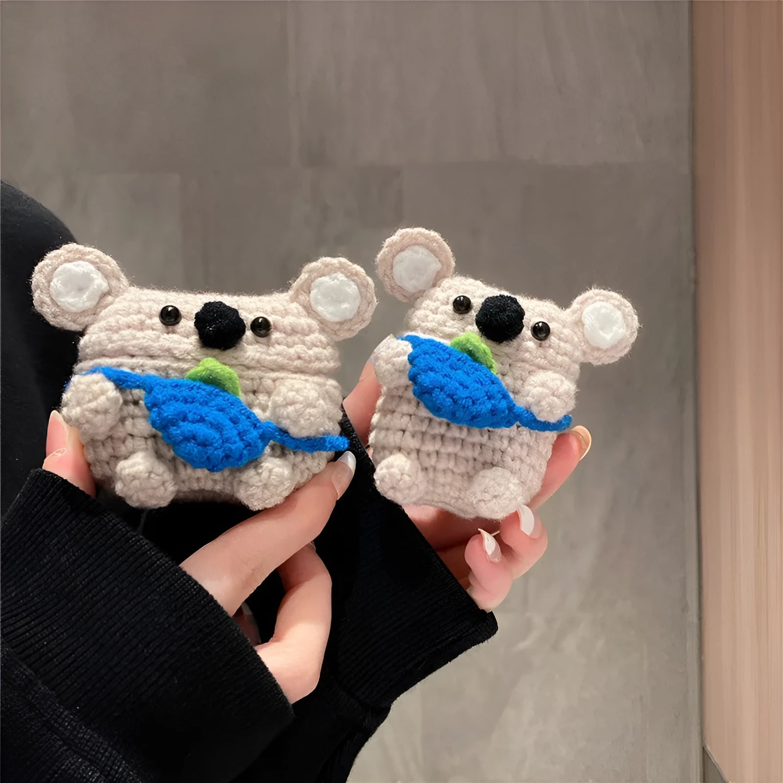 Handmade knitted grey koala bear backpack design cover on an Apple AirPods Pro charging case.