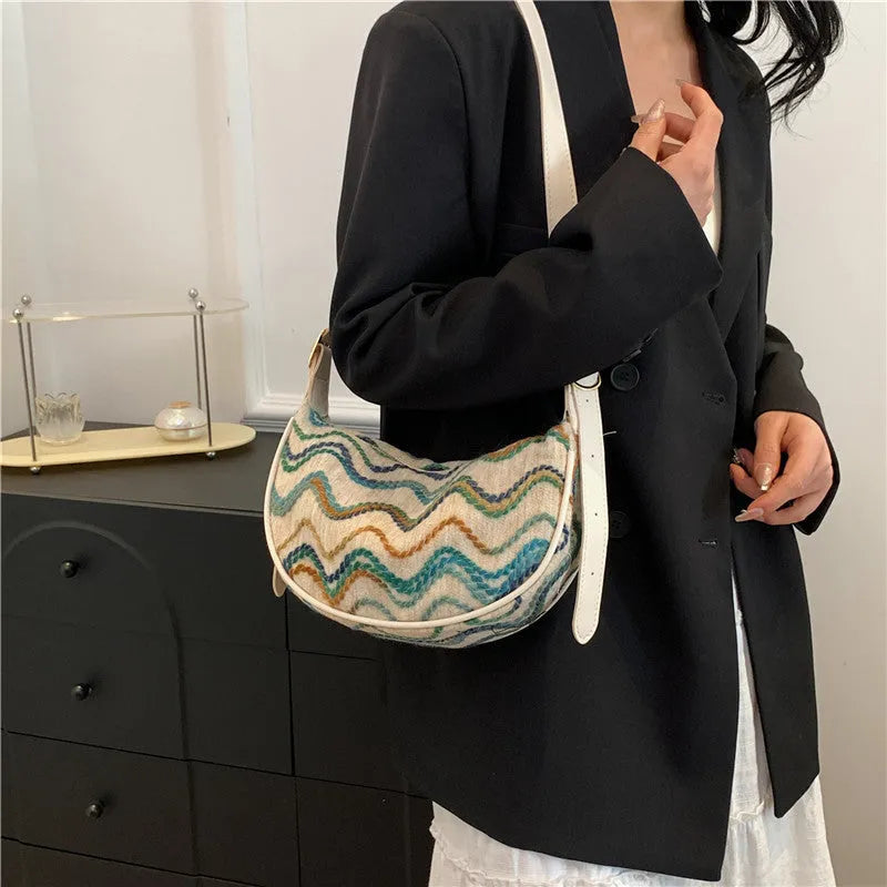 Straw woven crossbody bag showing woven texture and internal phone compartment