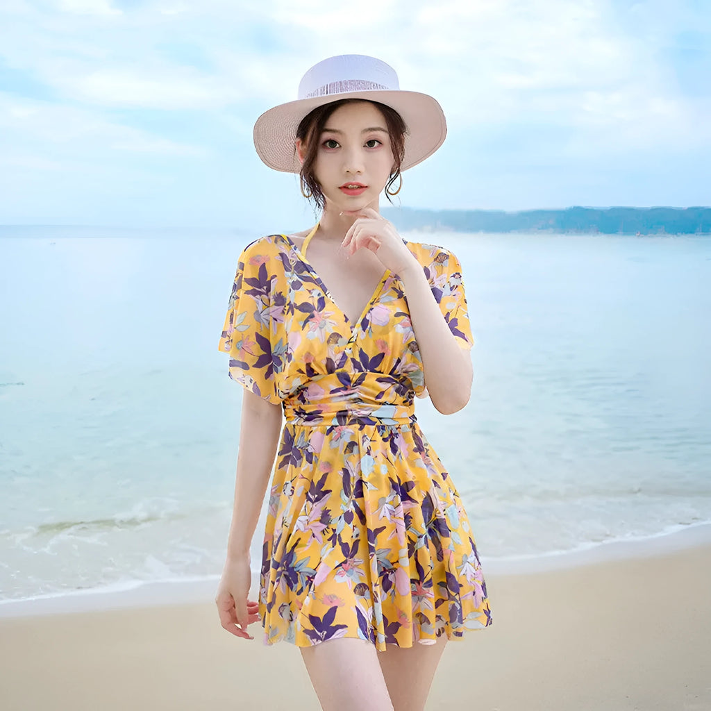 Yellow women's one-piece swimsuit with a floral pattern, shown on a hanger.