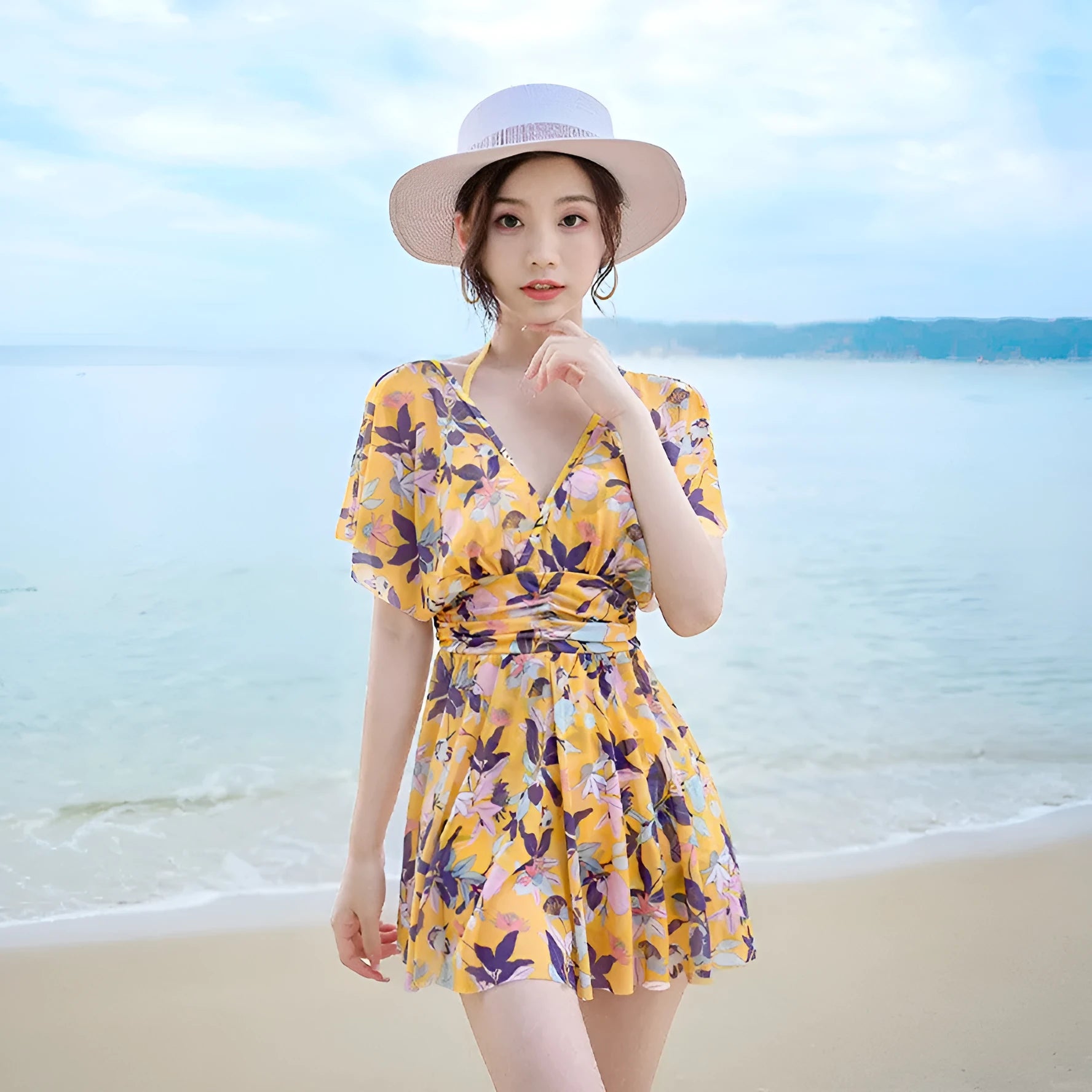 Yellow women's one-piece swimsuit with a floral pattern, shown on a hanger.