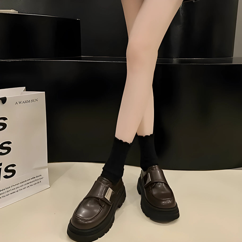 Women's black chunky square heel shoes with cross strap and round toe on a neutral background