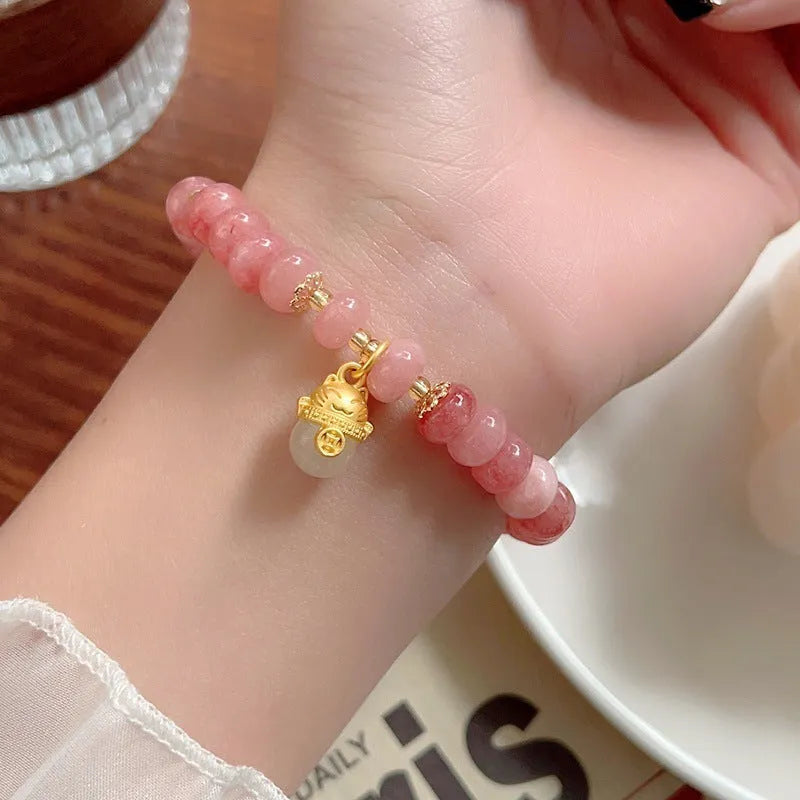 Women's strawberry quartz bracelet with a retro lucky cat charm in grey jade.