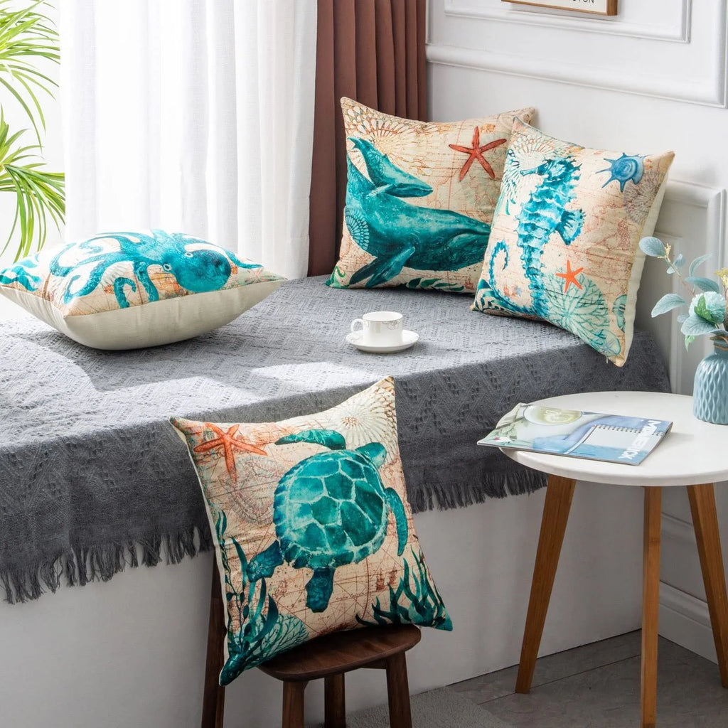 Square linen cushion cover with a detailed blue and green sea turtle print, shown on a grey sofa.