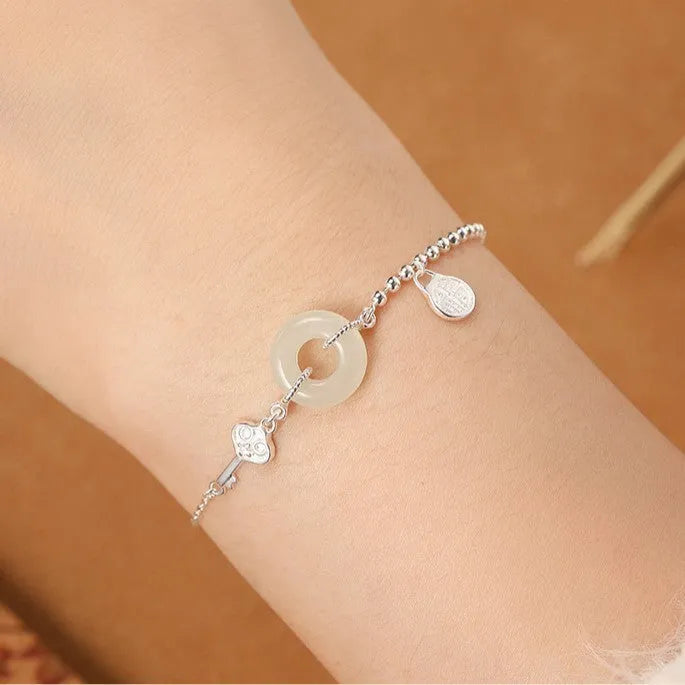 Silver Hetian jade bracelet with peace buckle charm and Chinese Ruyi Xiaofu design for women