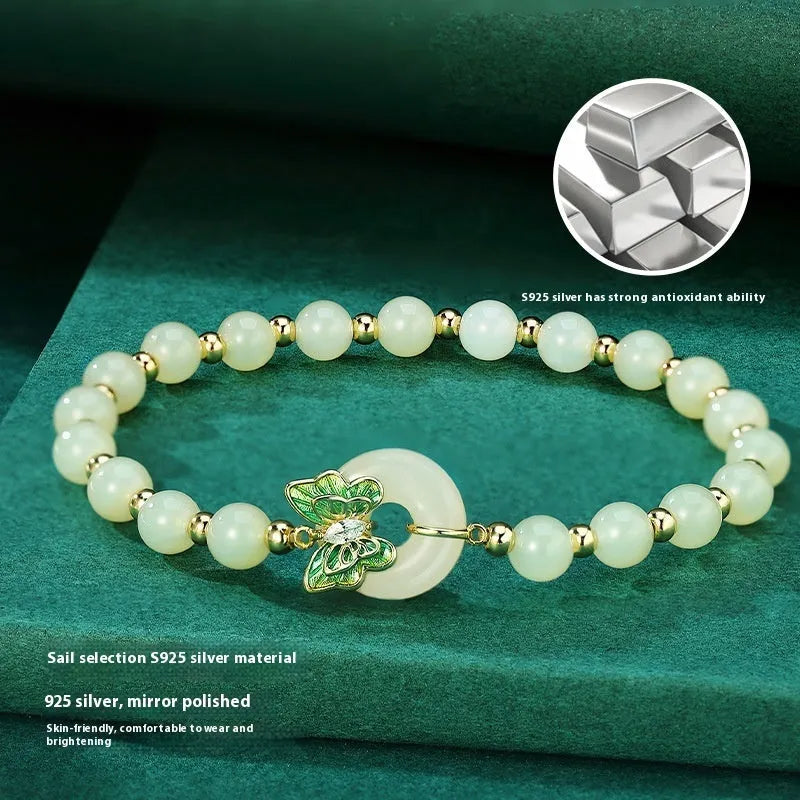 Cyan Hetian jade bracelet with a detailed sterling silver butterfly and gemstone ornament.