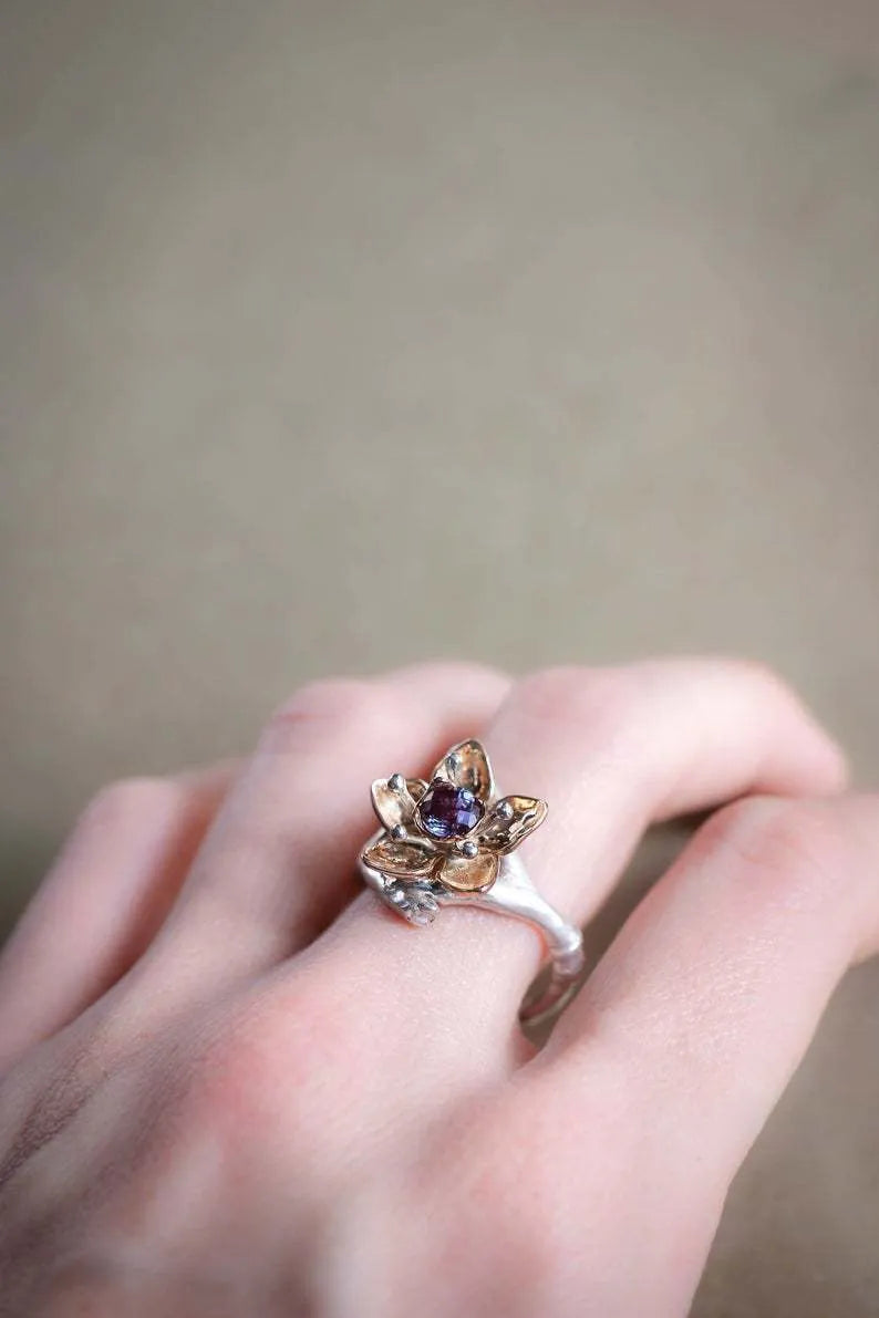 Silver two-tone geometric floral fashion ring for women on a hand.