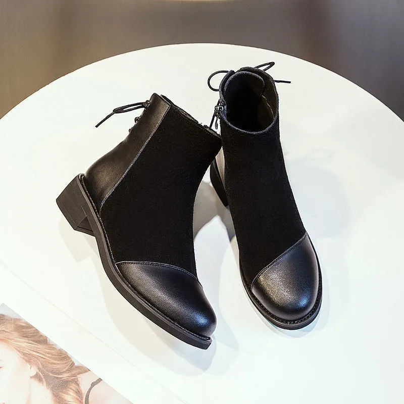 Black women's knee-high Martin boots with side zip, round toe, and block heel on a rubber sole.