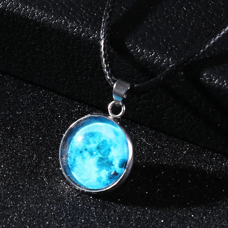 Luminous moon and constellation glass pendant on a silver alloy necklace chain with an extension piece.