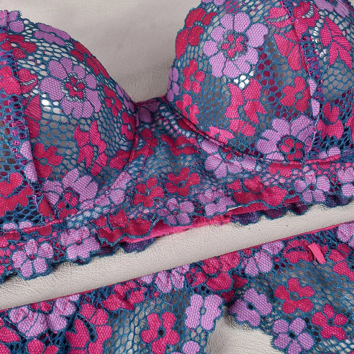 Rose red women's bikini set with floral embroidery on a white background.