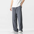 Man wearing beige cropped straight-leg linen trousers with a drawstring waist.