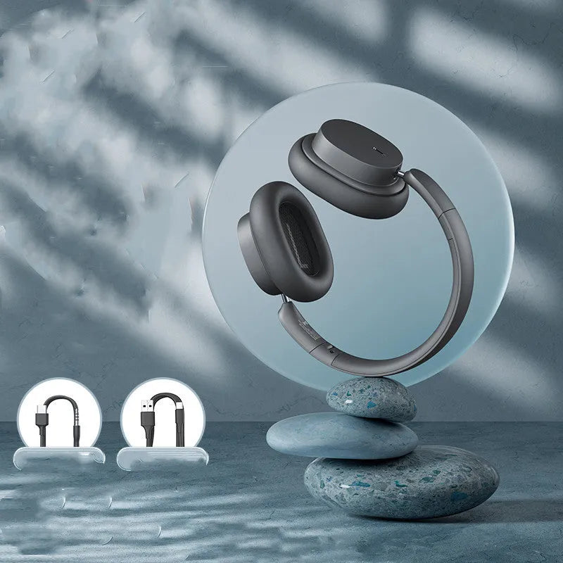 Beige and grey Bluetooth over-ear headphones with a Type-C charging cable on a table.
