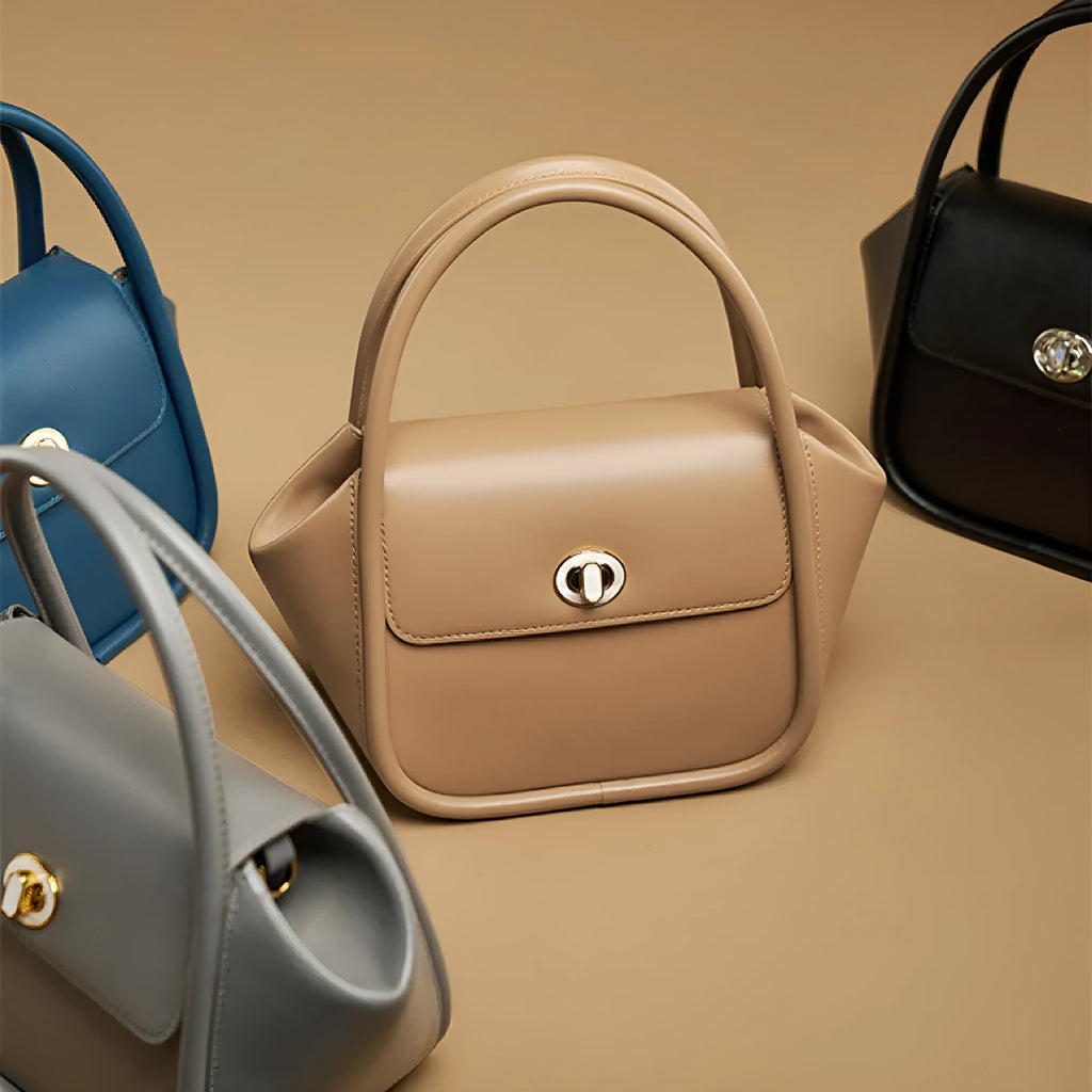 Women's leather wing tote bag in cow leather with a cross-body strap and buckle detail.