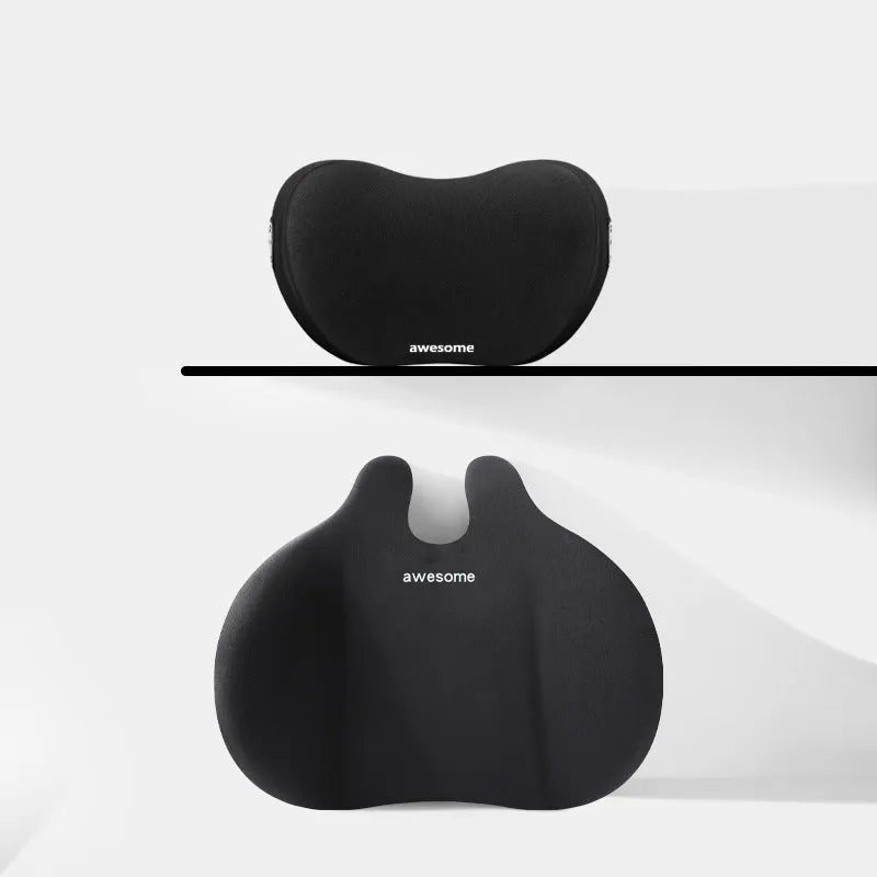Cow head style black automotive headrest pillow and matching lumbar support pillow on a car seat.