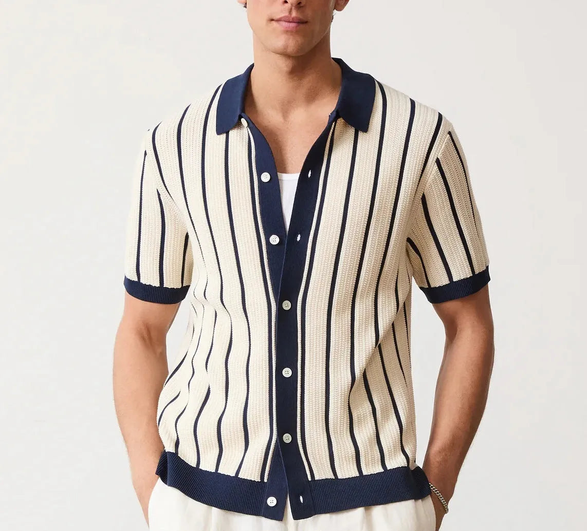 Man wearing a white asymmetric lapel knitted polo shirt with a striped pattern.