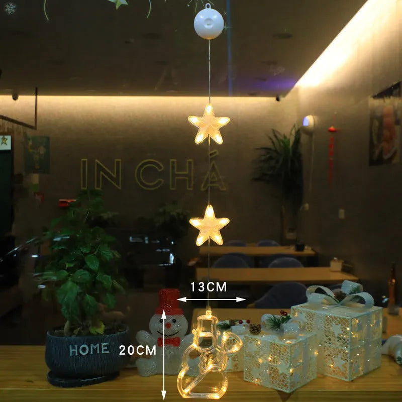 Three Christmas LED light ornaments with suction cups hanging on window
