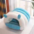 Blue enclosed cat nest with a round entrance, shown on a wooden floor.
