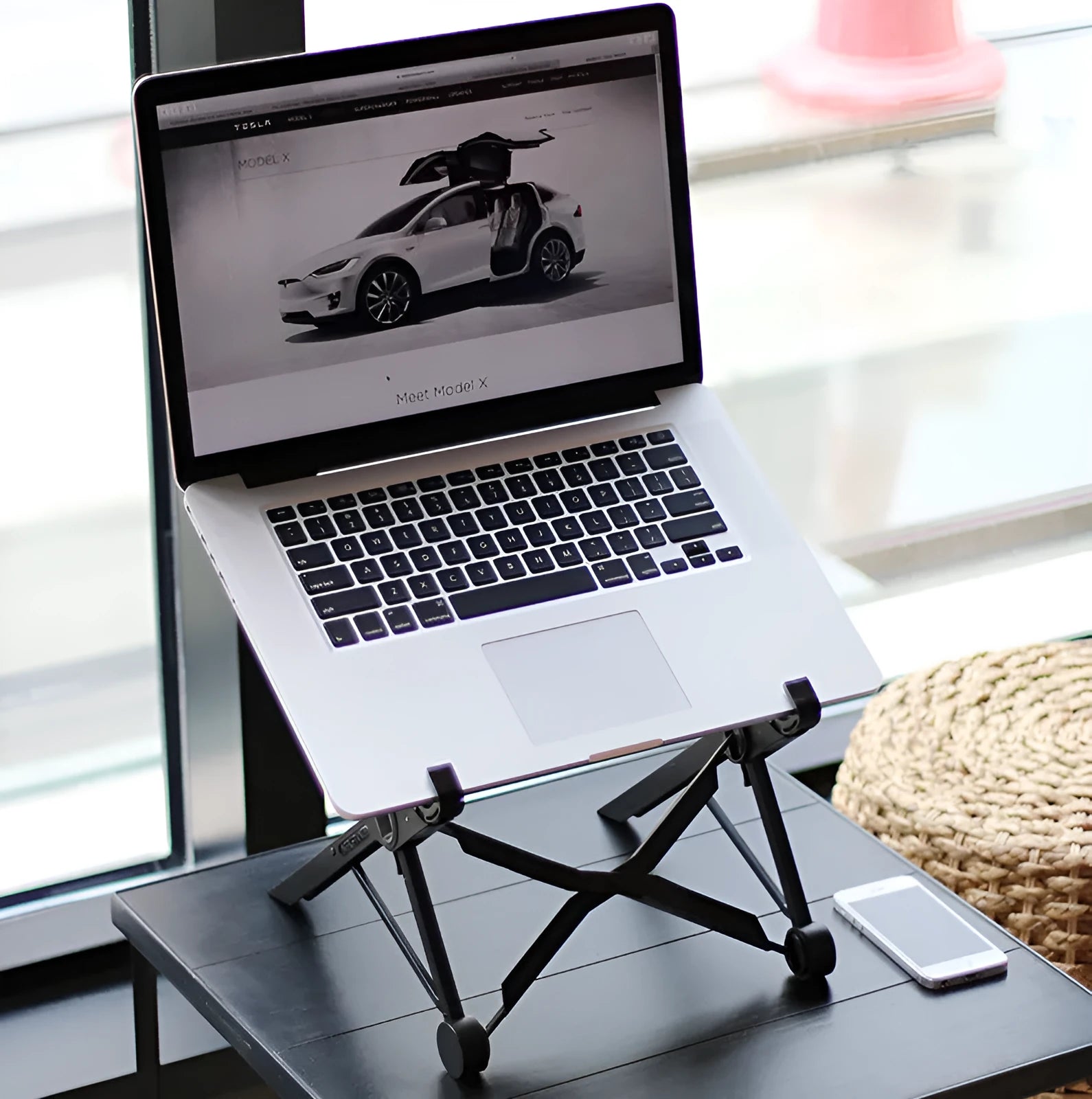Black folding portable laptop stand made from reinforced nylon, shown folded to its compact size.
