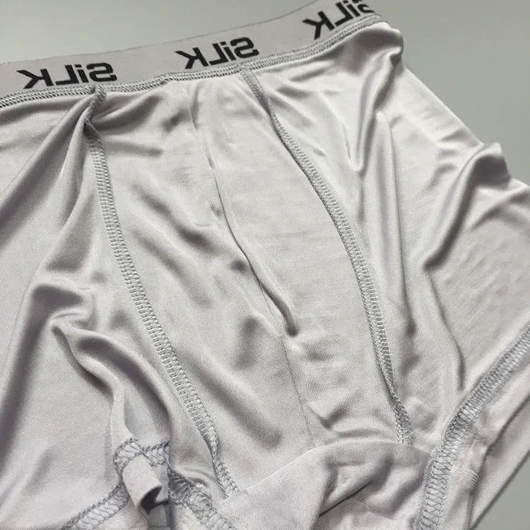 Men's loose-fit silk shorts in navy blue, shown on a mid-waist.