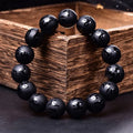 Natural frosted black agate Sanskrit mantra bracelet with Chinese auspicious patterns on a wrist.
