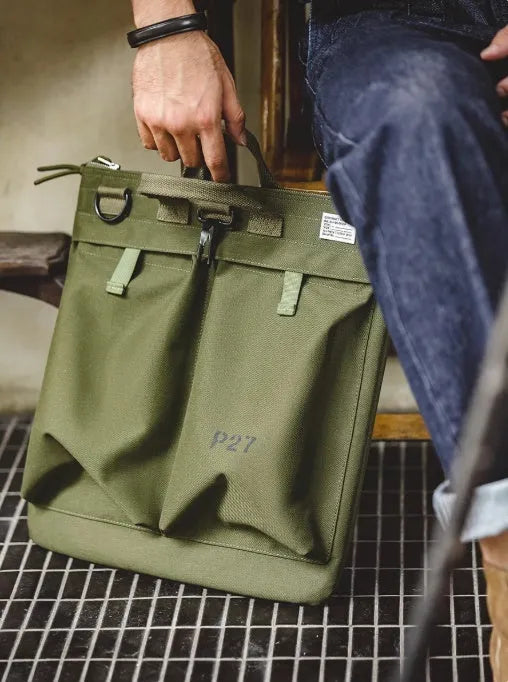 Military green canvas crossbody messenger bag with shoulder strap showing vertical square shape and zipper closure