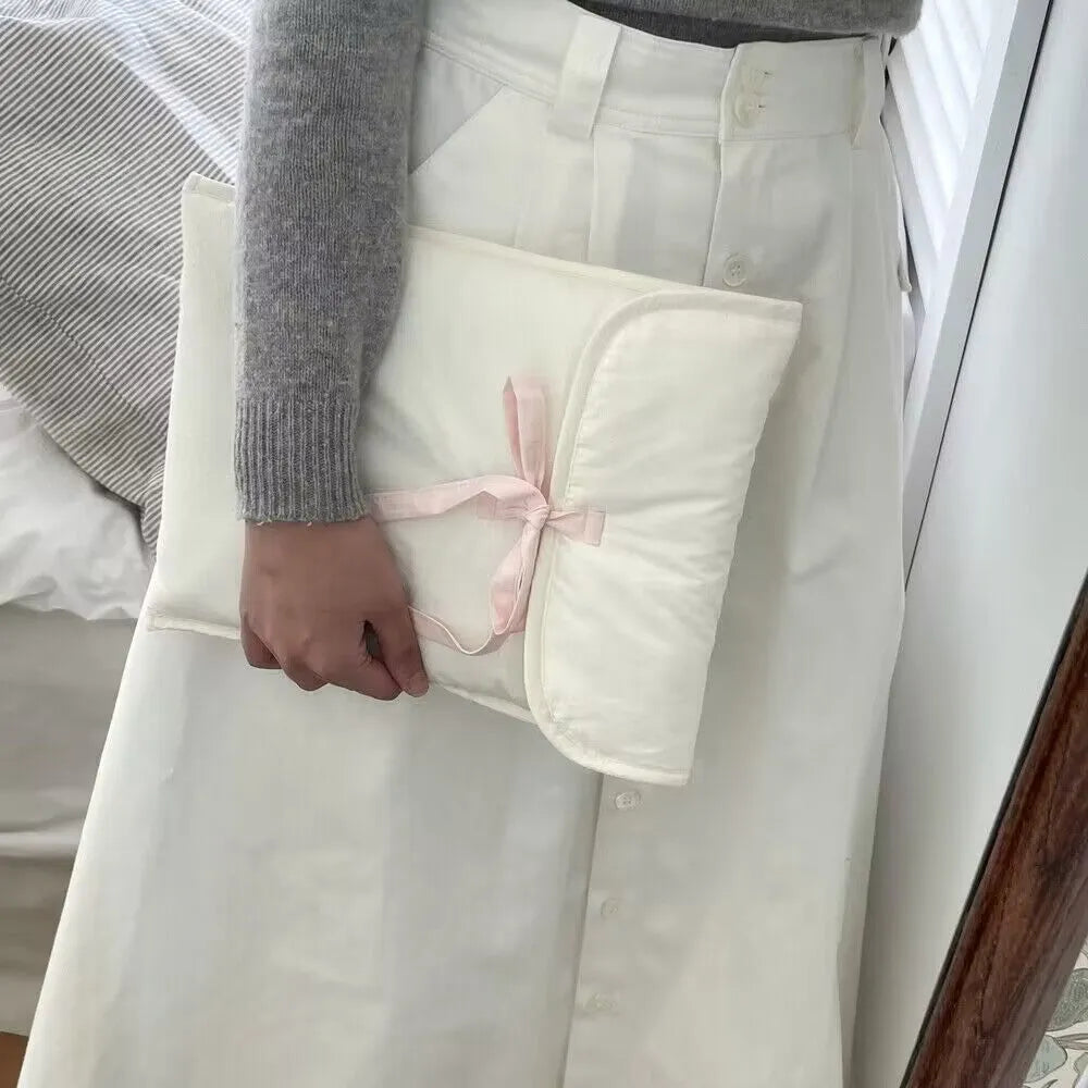 Women's quilted laptop bag with bow detail in nylon, showing striped lining and size options