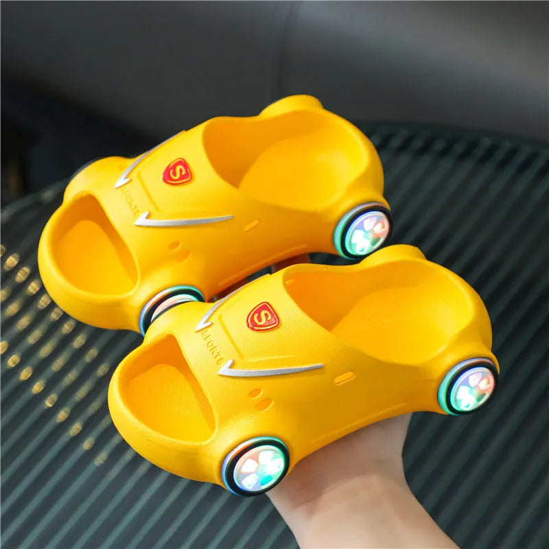 Children's luminous cartoon car slippers with anti-slip soles in blue, black, white, yellow, and pink colours.