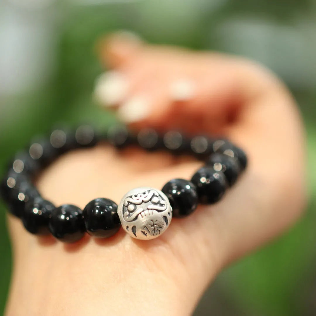 Close-up of a women's bracelet with a large 10mm black agate bead and sterling silver clasp in a Chinese style design.