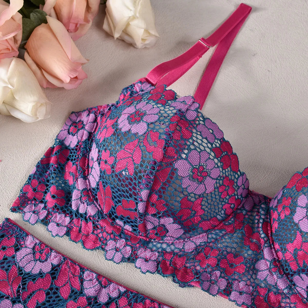 Rose red women's bikini set with floral embroidery on a white background.