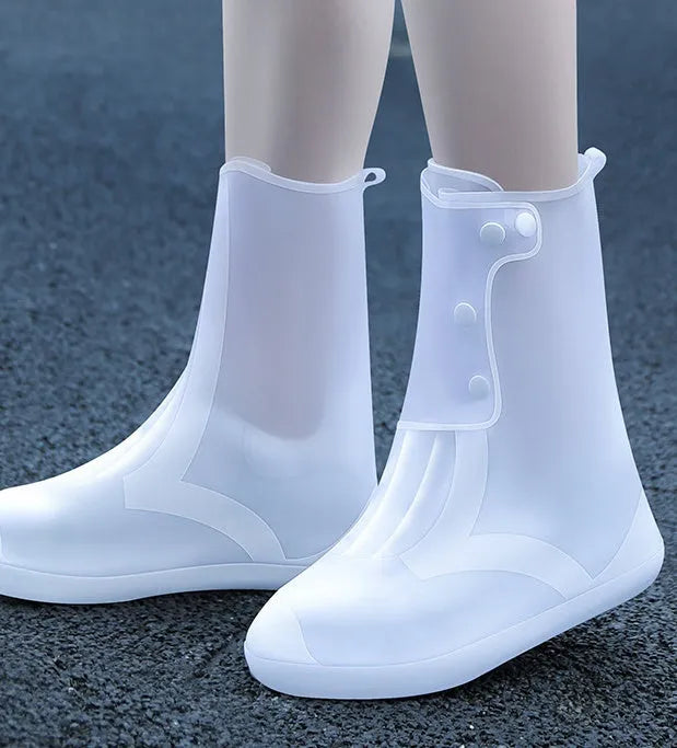 White PVC high-top reusable shoe covers for women, shown on feet.