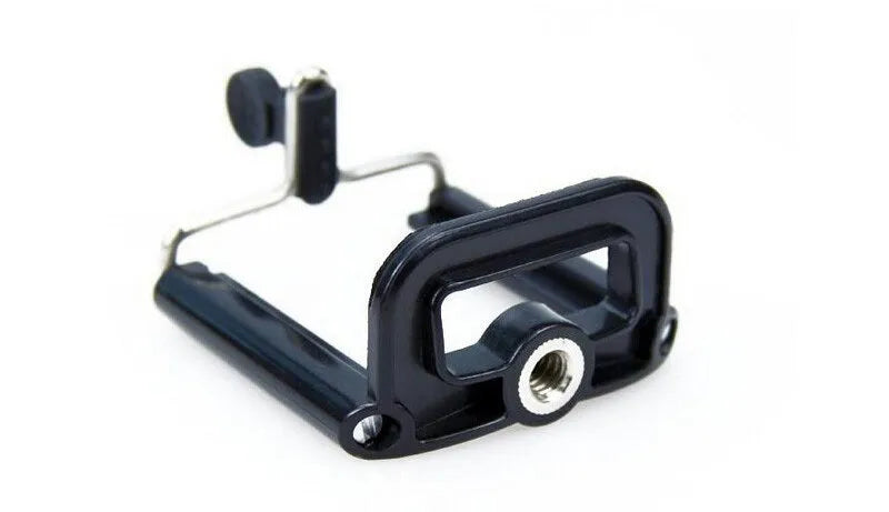 Black mini flexible tripod extended on a table with a silver U-shaped phone clip attached.
