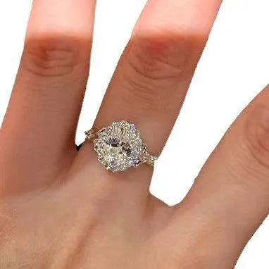 Silver geometric ring with a large diamond detail and adjustable opening on a woman's index finger.