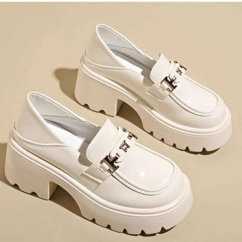 Black slip-on chunky heel shoes with a skull pattern on the front and a square rubber sole.
