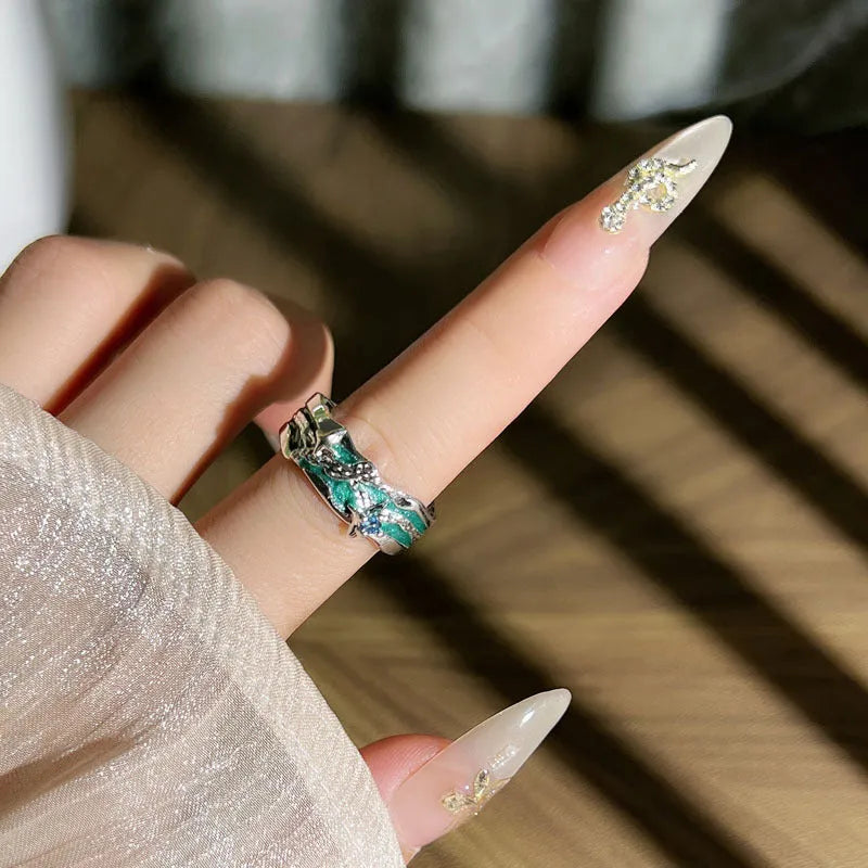 Mint green and copper asterism ring with asymmetric folding design on a hand.