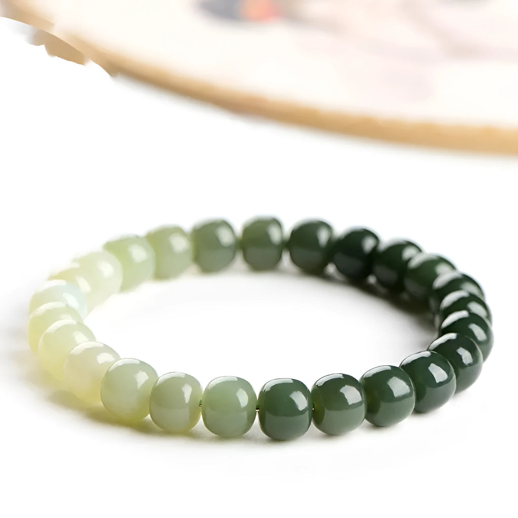 Natural Hetian jade bracelet with gradient clear water colours on a wrist, showing polished beads.