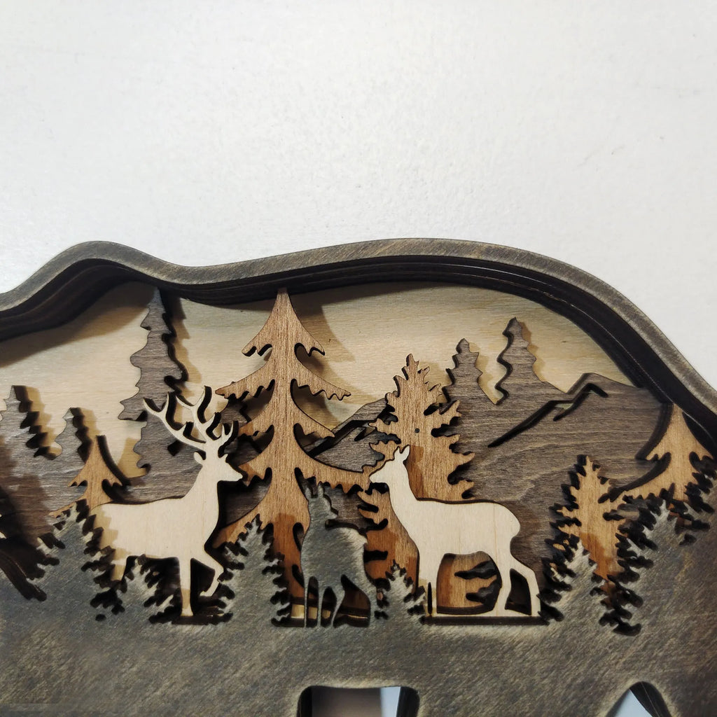 Two boxwood wooden ornaments, elk and brown bear, on a flat surface with natural wood finish