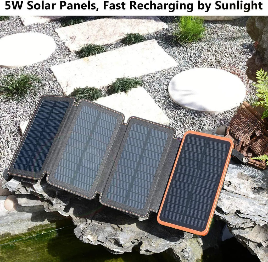 Black outdoor solar power bank with a solar panel and a built-in LED light displayed on a rock.