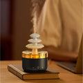 White cloud-shaped USB humidifier and essential oil diffuser with colourful mood lights on a wooden table.