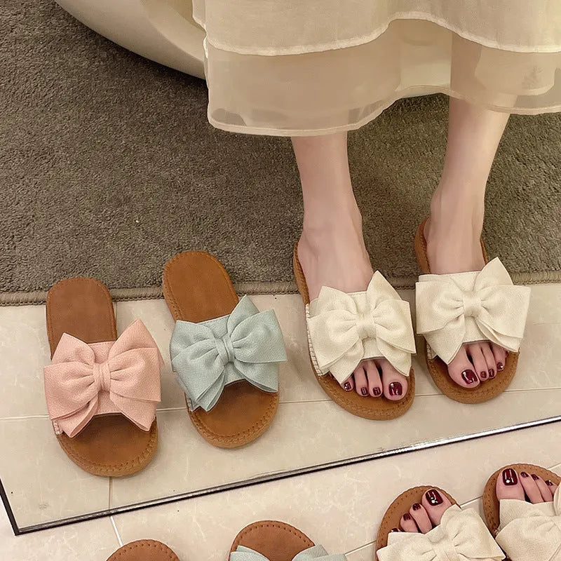 Women's beige suede sandals with bow detail and flat rubber soles