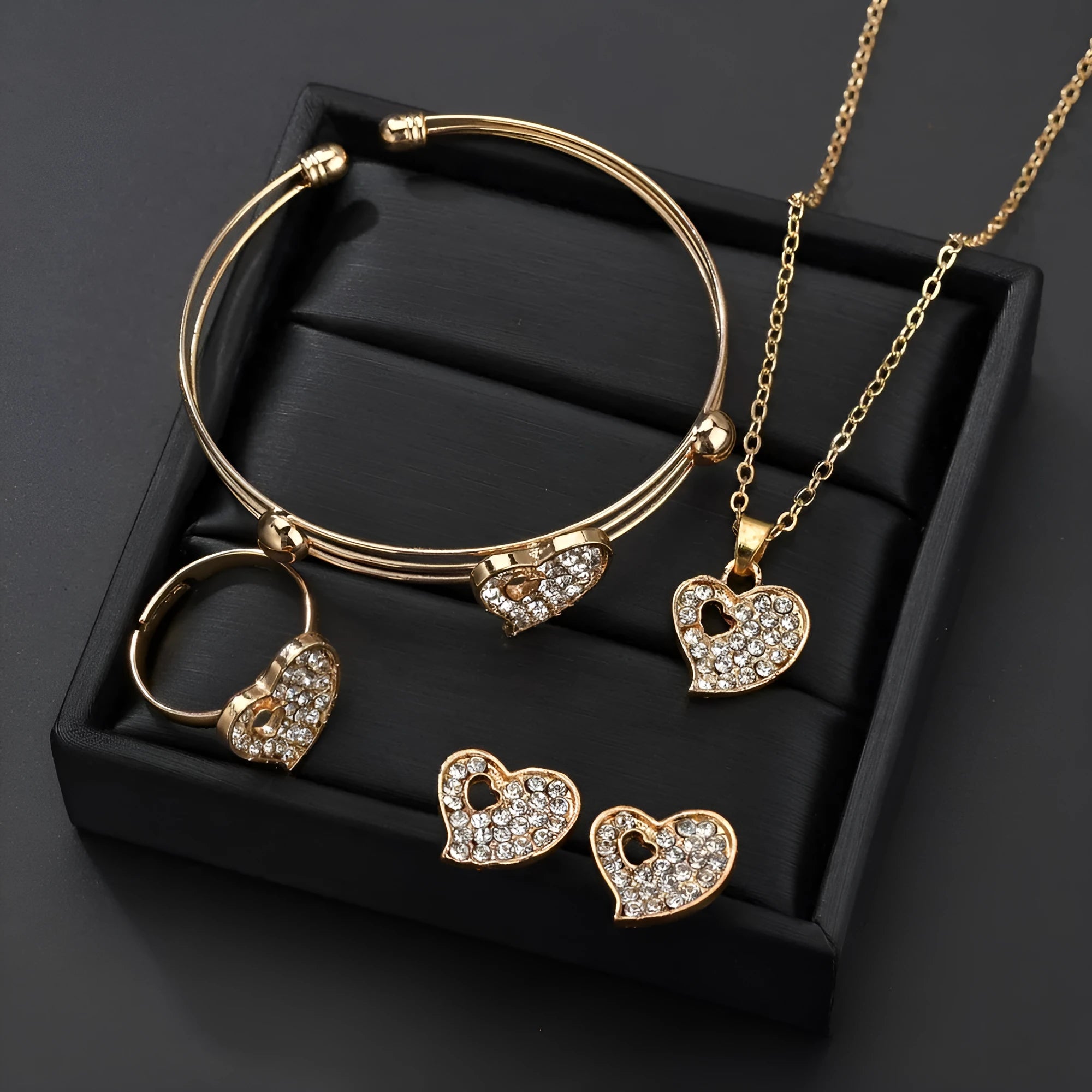 Gold tone alloy jewellery set with earrings, pendant and bracelet featuring love, water drop or bell patterns