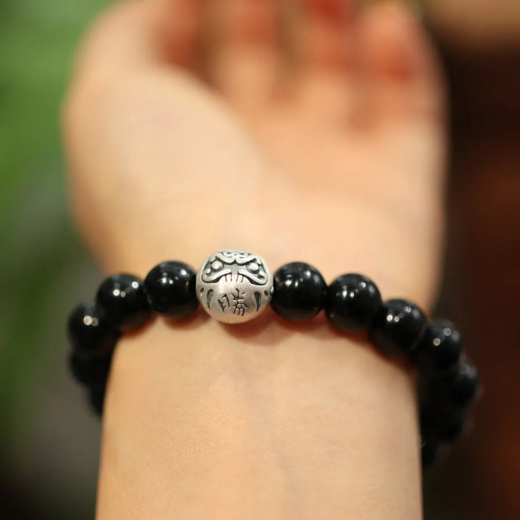 Close-up of a women's bracelet with a large 10mm black agate bead and sterling silver clasp in a Chinese style design.
