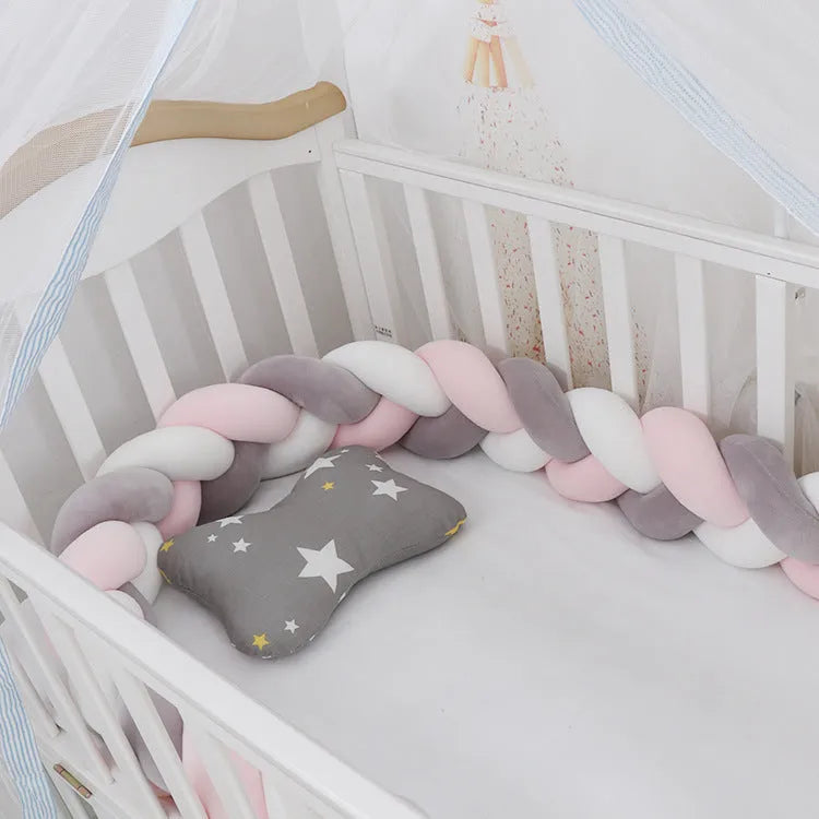 Bendable braid knot baby crib bumper in spandex velvet fabric on a white cot.