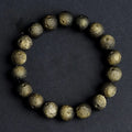 Natural obsidian crater ball bracelet with textured beads in silver stone meteorite colour on a wrist.