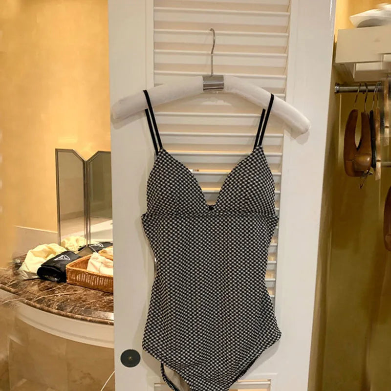 Blue one-piece swimsuit for women offering belly coverage, shown on a hanger.