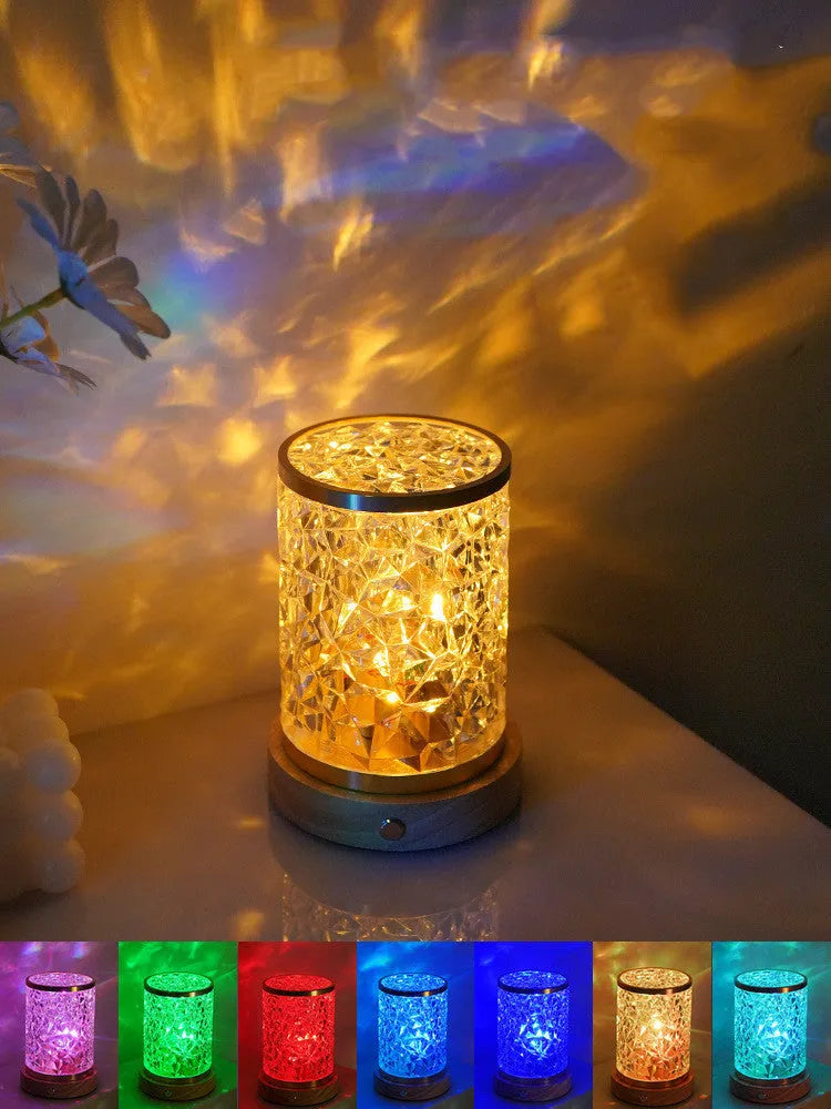 Small rotating water ripple night light with a solid wood base and acrylic body on a bedside table.